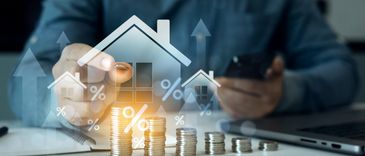 Person using tablet with house and percentage graphics over coins.