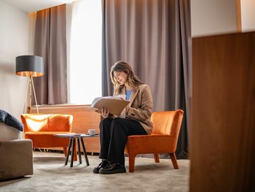 Woman reading a book in a cozy living room.