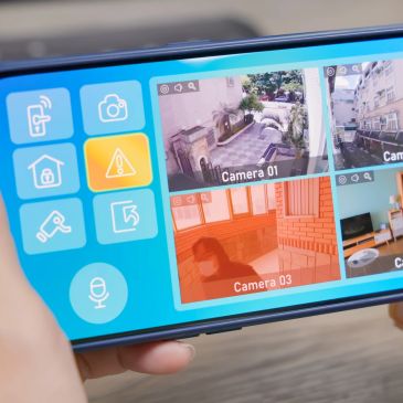 Person monitoring four security cameras on a smartphone.