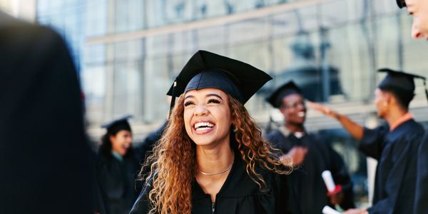 Happy graduate smiling in cap and gown.