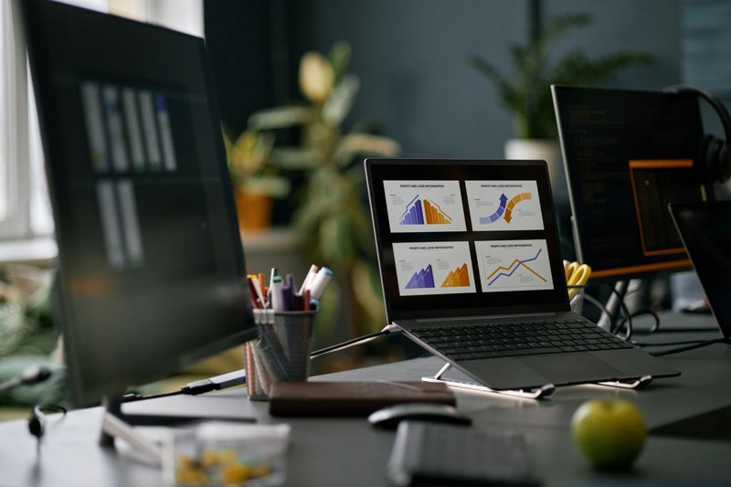 Workspace with computer screens displaying various data graphs and charts. Modern office setting with a focus on technology and data analysis making it optimal for business tasks