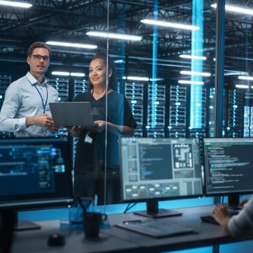 Two IT professionals collaborating in a server room.