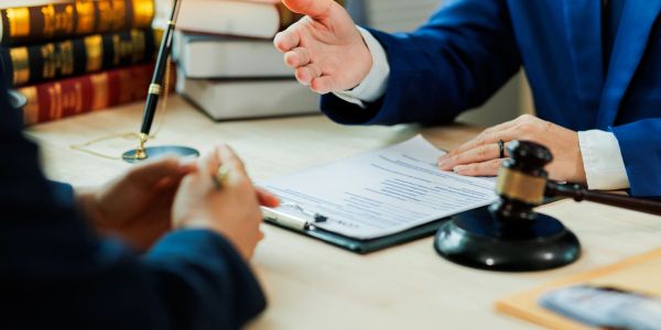 Discussão legal entre advogados com documentos e martelo.