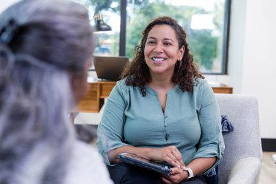 A woman smiling and listening attentively during a conversation.