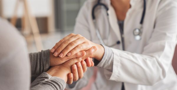Doctor comforting patient with a hand gesture.
