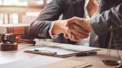 Two business professionals shaking hands in an office.
