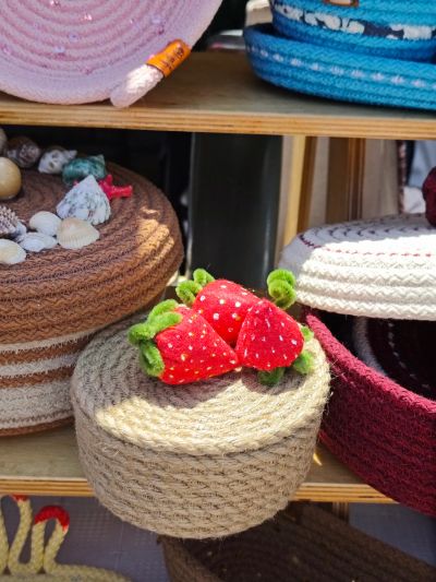 Handmade woven baskets, one topped with knitted strawberries.