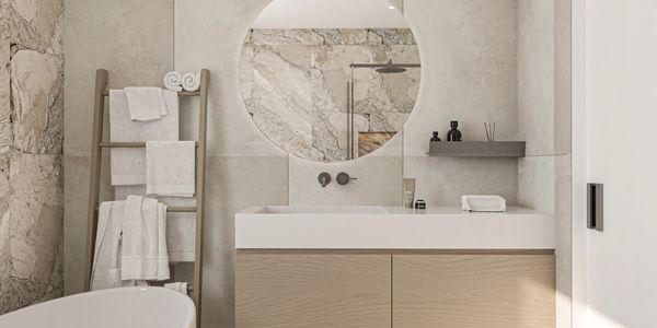 Modern bathroom with round mirror and wooden towel rack.
