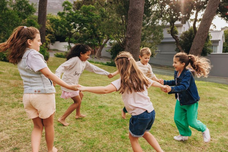 Children playing outdoors in a green park.