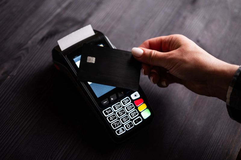 Girl Holding Card In Hand Paying By Credit Card With Wireless Pos Terminal