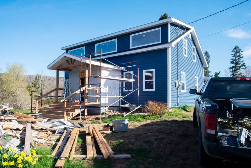 A house in a rural setting undergoing a major renovation. The front door is about to be installed.