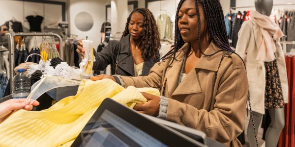 Two women shopping for clothes in a store.