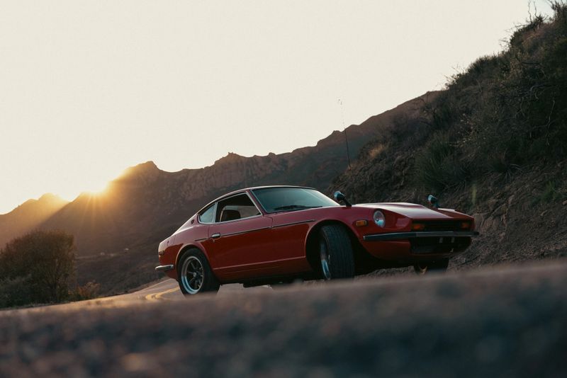 Red Vintage Car on Southern California mountain winding roads at sunset.