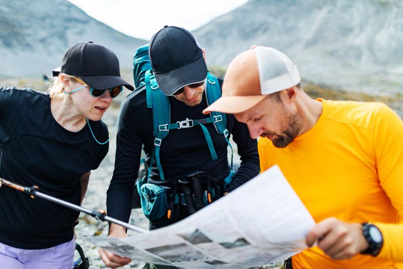 Friends lost direction and examining map during hiking in mountains