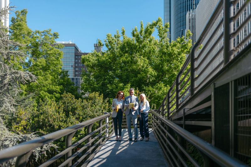 Business people reviewing contract outdoors in urban park