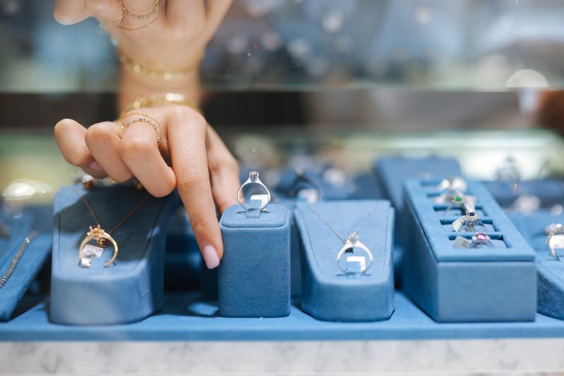The female clerk in the jewelry store took out the jewelry on the counter and prepared to introduce it to the customers. There were diamond rings, pearl bracelets, jade pendants, etc., all kinds of high-end accessories on the counter.
