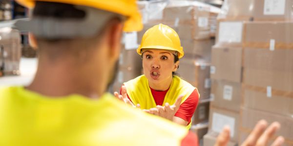 Female worker arguing with a male colleague in a warehouse.