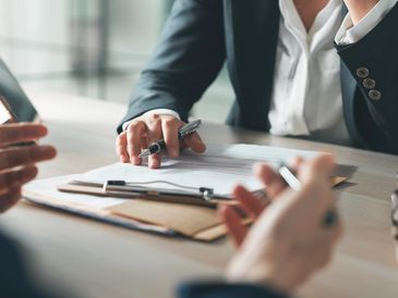Two professionals reviewing documents and discussing work details.