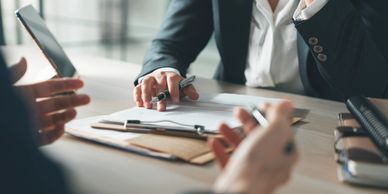 Two professionals discussing documents during a business meeting.