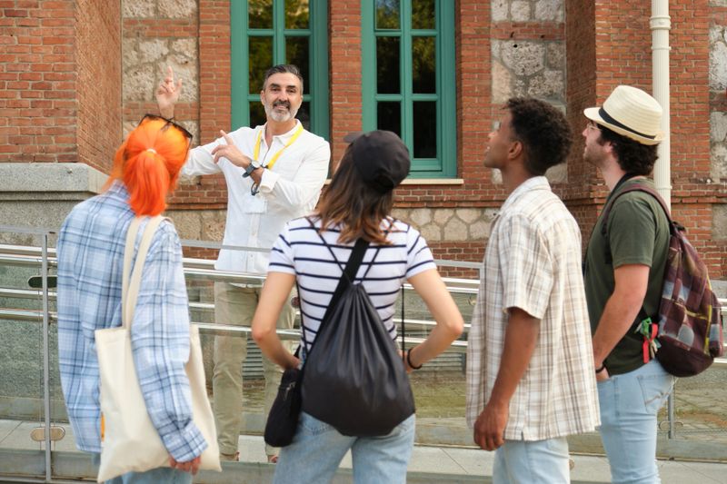 Tour guide showing historical building to tourists during a guided tour in a sunny day