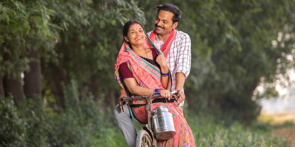 Happy couple enjoying a bike ride together in a lush rural setting.