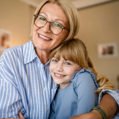 Smiling grandmother hugging her granddaughter.