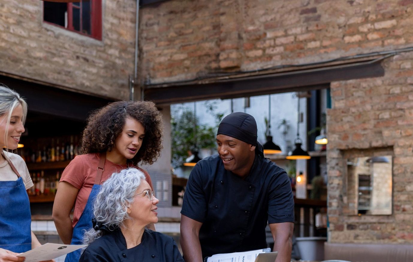 Restaurant team discussing work together with smiles.