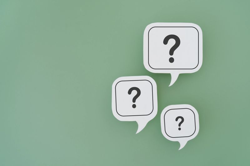 For FAQ , Frequently asked questions concept, asked questions  and answers. Question mark on  different size of white speech bubble real paper cut on green background, copy space included