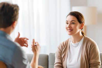 Two people engaged in a friendly conversation in a bright room.