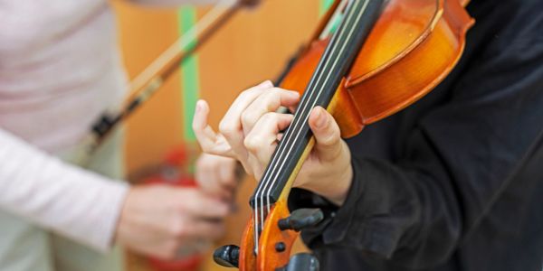 Close-up of hands playing a violin.
