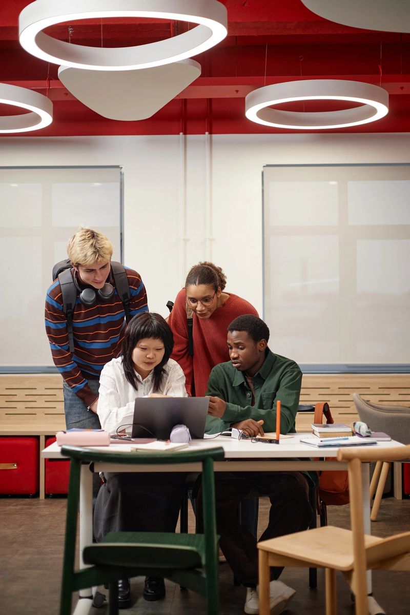 Vertical full length shot of diverse college students collaborating in classroom setting with modern design