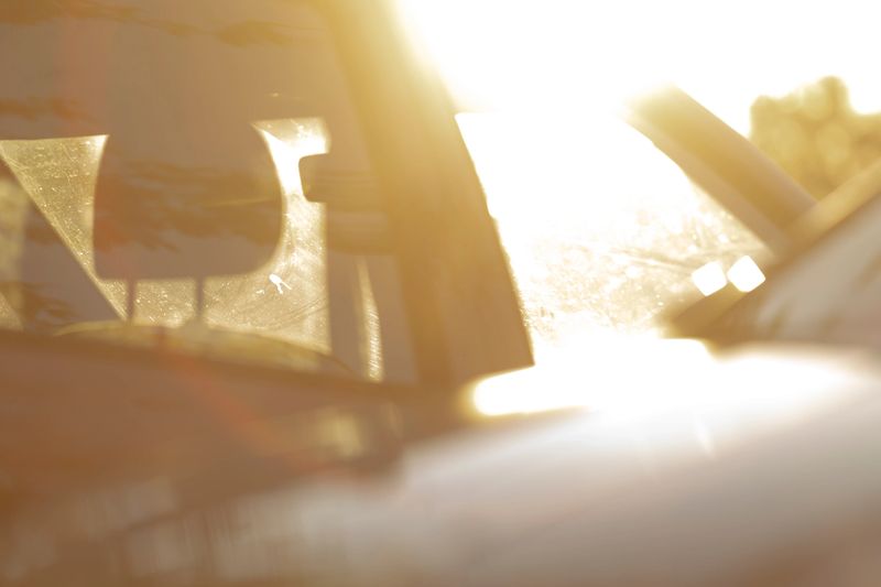 Warm sunlight gently streams through a car window, beautifully illuminating the interior and creating soft, dreamy reflections