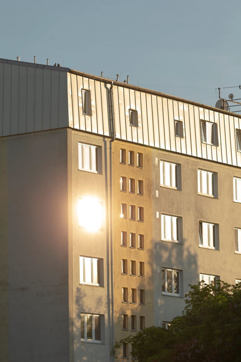 A contemporary apartment building that beautifully reflects sunlight, showcasing the impressive details of urban architecture