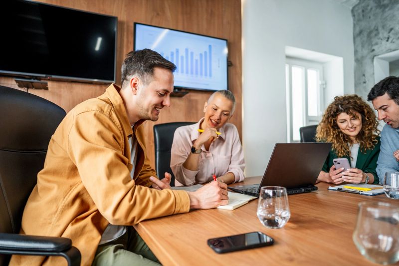 Business team working together on a project, using laptops and taking notes during a productive meeting in a modern office
