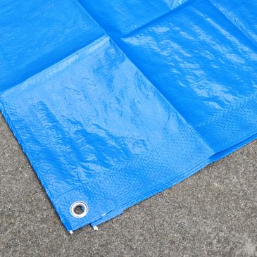 Blue tarpaulin laying on grey carpet