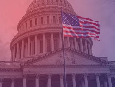 American flag waving in front of the U.S. Capitol dome.
