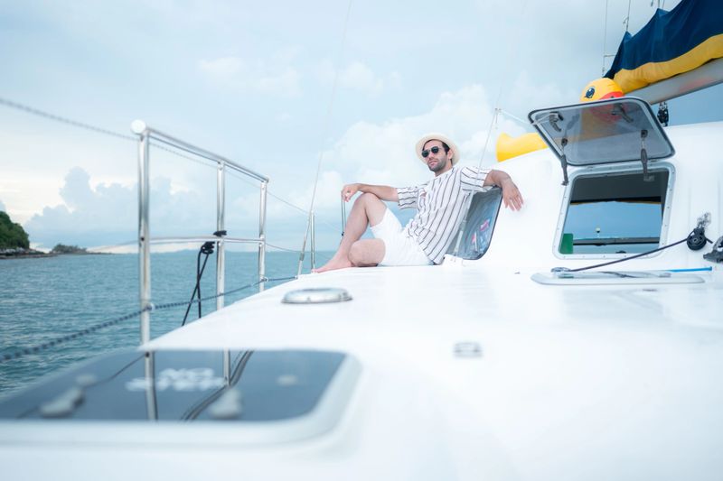 A young man is enjoying his seaside adventure aboard a yacht