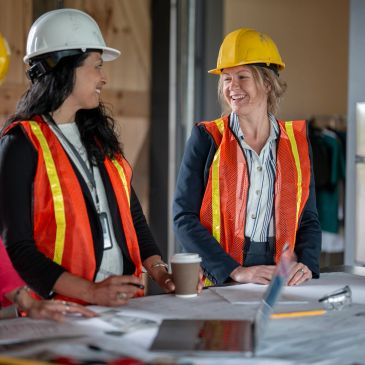 Two female construction workers discussing plans.