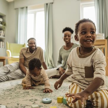 Happy family playing with toys on the living room floor.