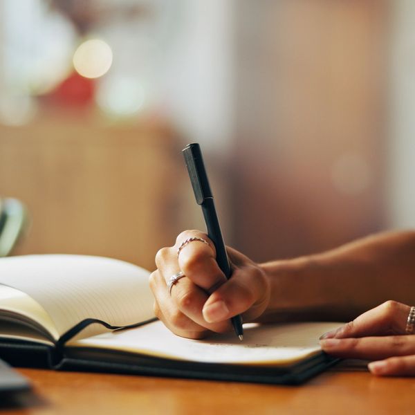 Women sitting writing in her journal