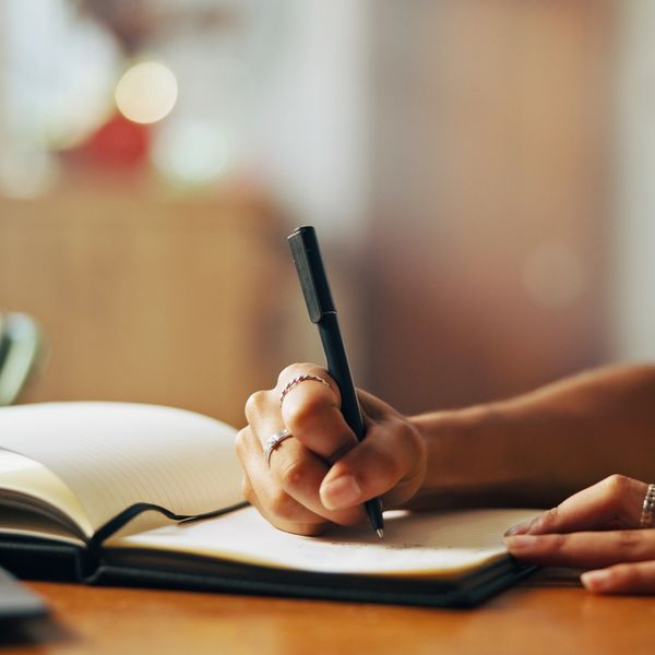 Women sitting writing in her journal