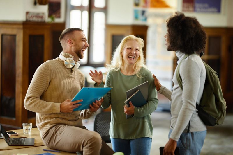 Team of cheerful creative colleagues having fun while communicating at casual office.