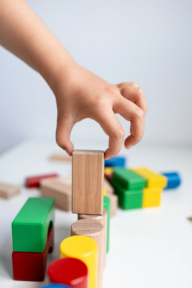 Child playing with colorful wooden blocks. High quality.