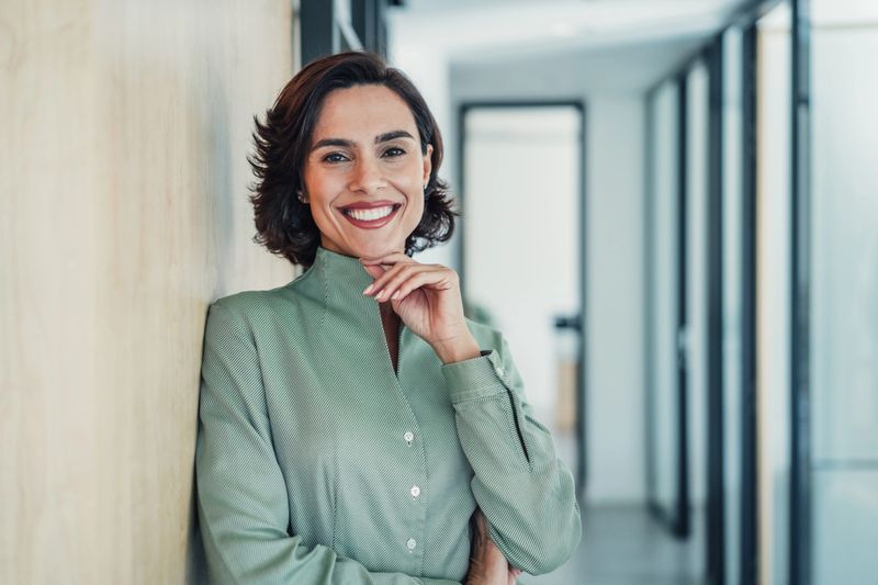 Portrait of a beautiful smiling businesswoman standing in her office and looking at camera.