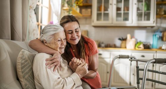 Elderly man receiving assistance indoors.