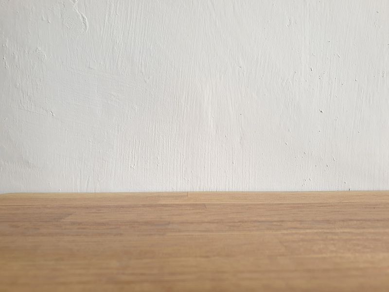 Clean wooden texture base with soft white background, perfect for showcasing product shots in minimalist and modern design settings