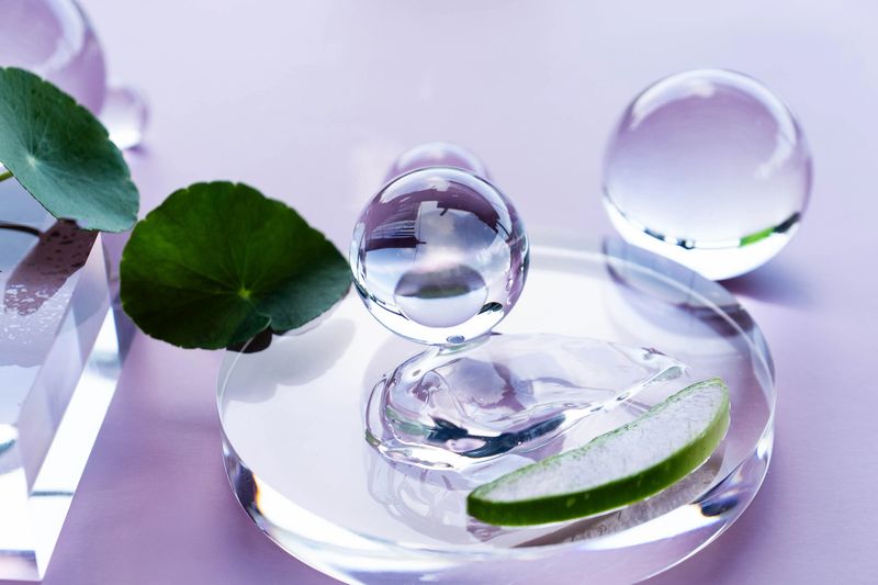 A serene arrangement of clear droplets and aloe slices creates a calming spa ambiance.