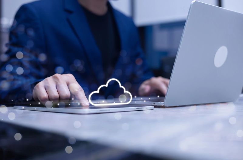 businessman hand touch on digital tablet to use cloud computing function on program for access or check database and store information and transfer from server to client in office room concept