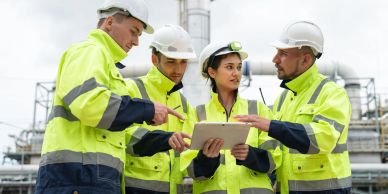 Equipo de ingenieros discutiendo en una obra industrial.