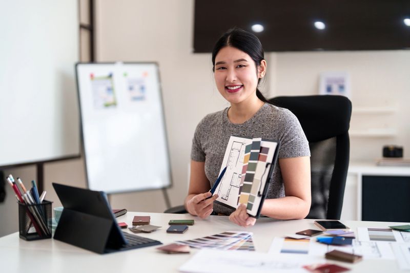 Young architect presenting interior design ideas through tablet during online meeting in creative office